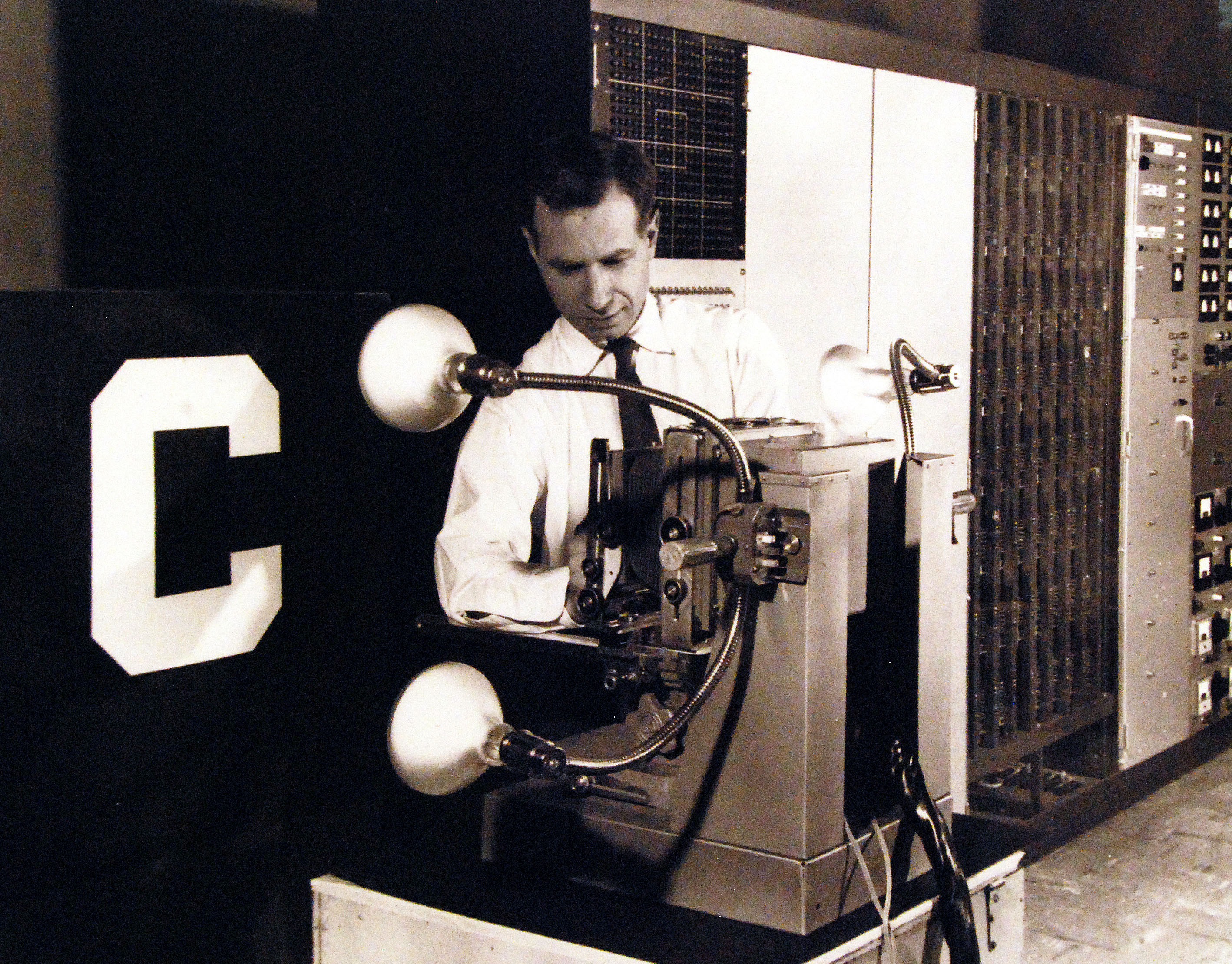 The Mark 1 Perceptron, being adjusted by Charles Wightman (Mark I Perceptron project engineer).Sensory units at left, association units in center, and control panel and response units at far right. The sensory-to-association plugboard is behind the closed panel to the right of the operator. The letter "C" on the front panel is a display of the current state of the sensory input.